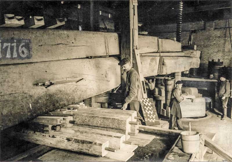 Das Holz wird auf den Trauben aufgestapelt um den Druck zu verteilen im Torkel in Markdorf